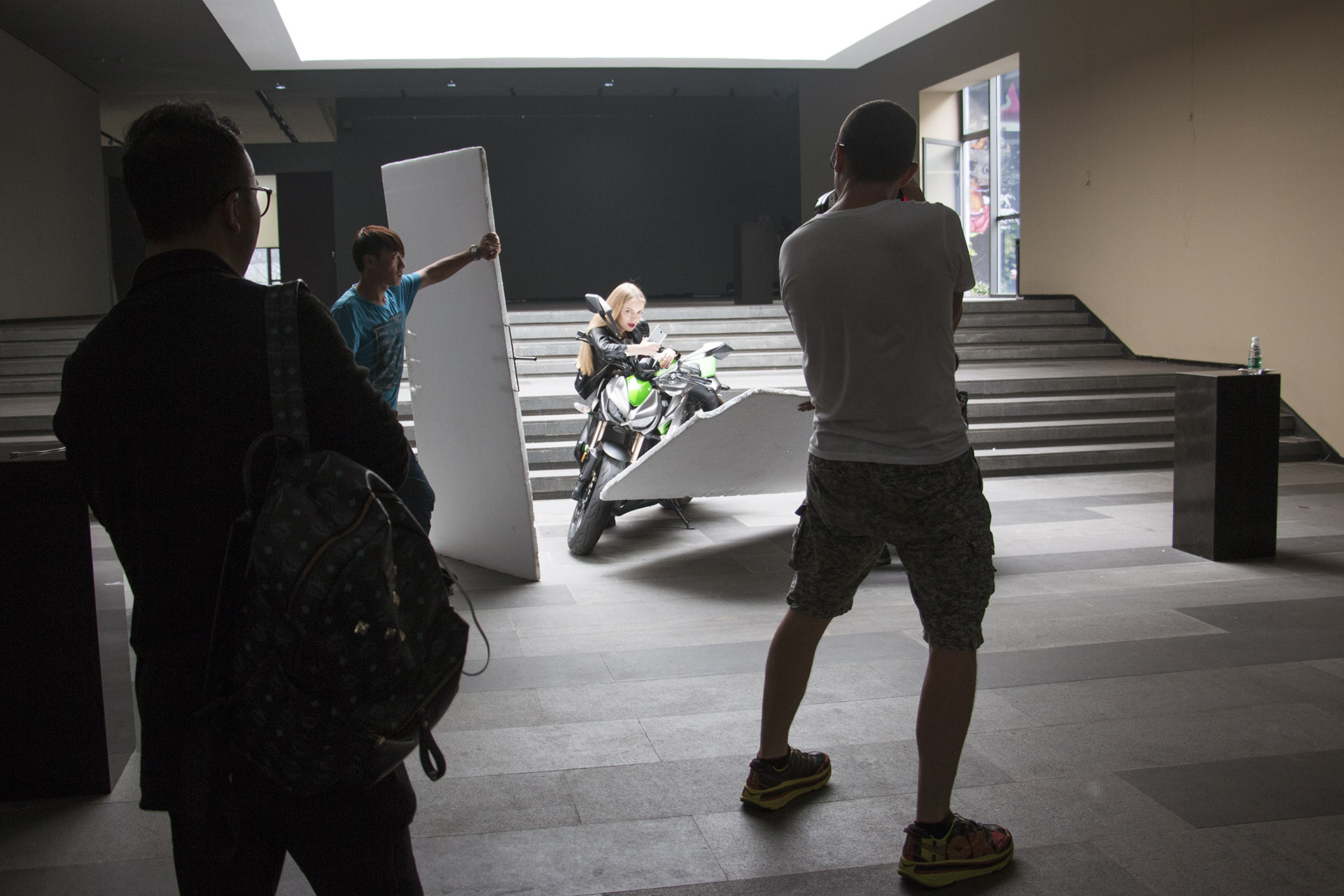 Photographer photographing a model on a motorcycle in an art gallery China